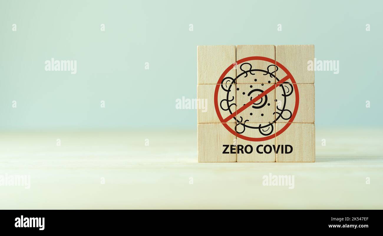 Medical und Covid-19 Zero Covid Konzept. Coronavirus-Viruszelle symbolisch. Die Holzwürfel mit ZERO COVID Symbol auf grauem Hintergrund und Kopierraum. Cov Stockfoto