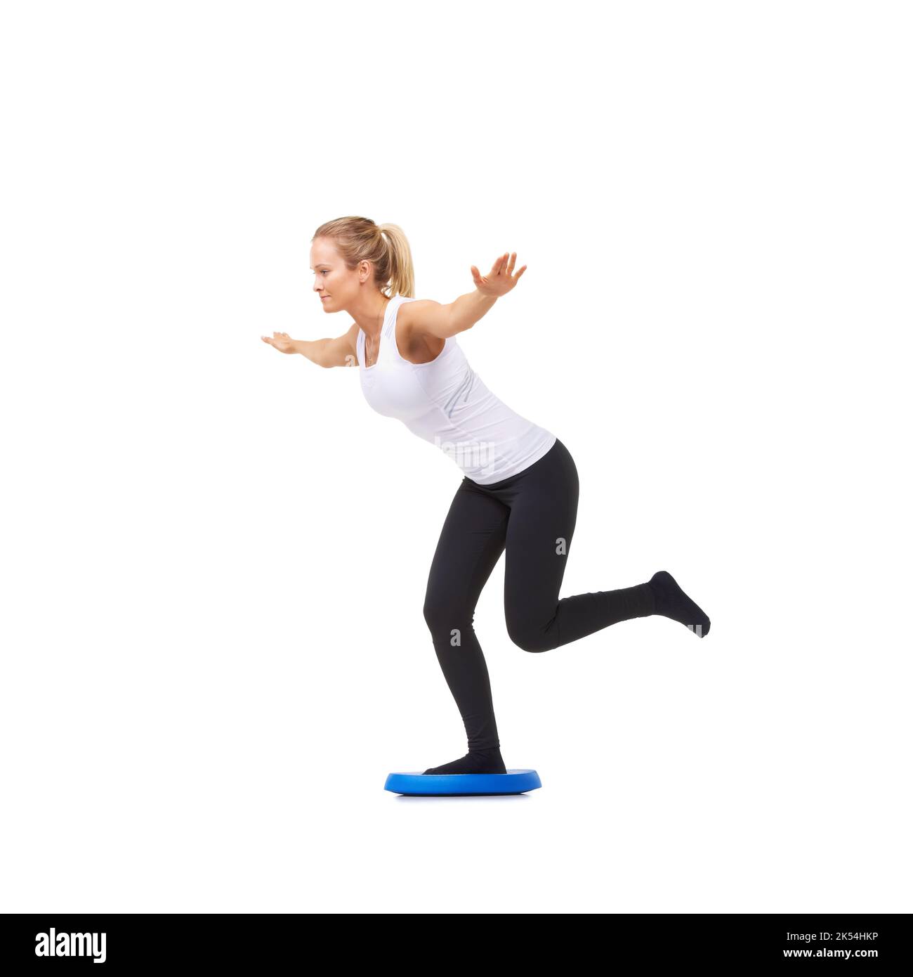 Fokus auf Gleichgewicht. Studioaufnahme einer jungen Frau, die isoliert auf Weiß balancierende Übungen macht. Stockfoto