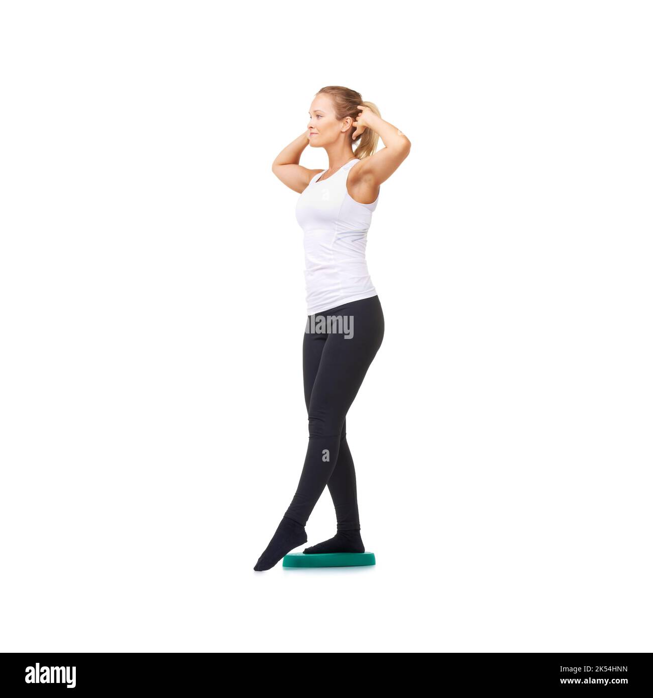 Konzentrieren Sie sich auf die Haltung. Studioaufnahme einer jungen Frau, die isoliert auf Weiß Gleichgewichtsübungen macht. Stockfoto