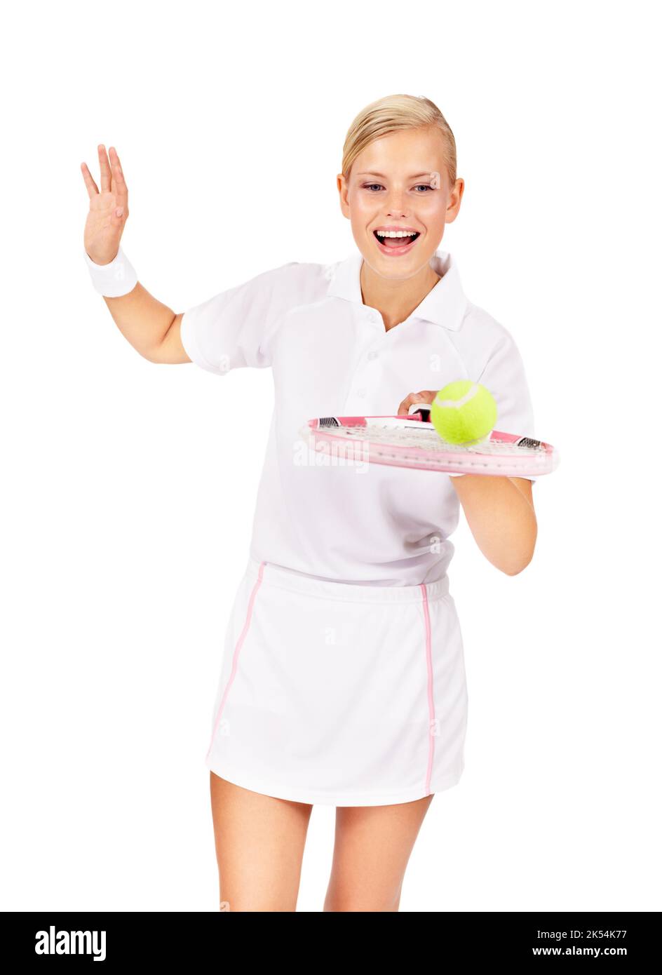Balanciert ihre Tenniskünste aus. Eine attraktive junge Frau balanciert einen Tennisball auf ihrem Schläger. Stockfoto