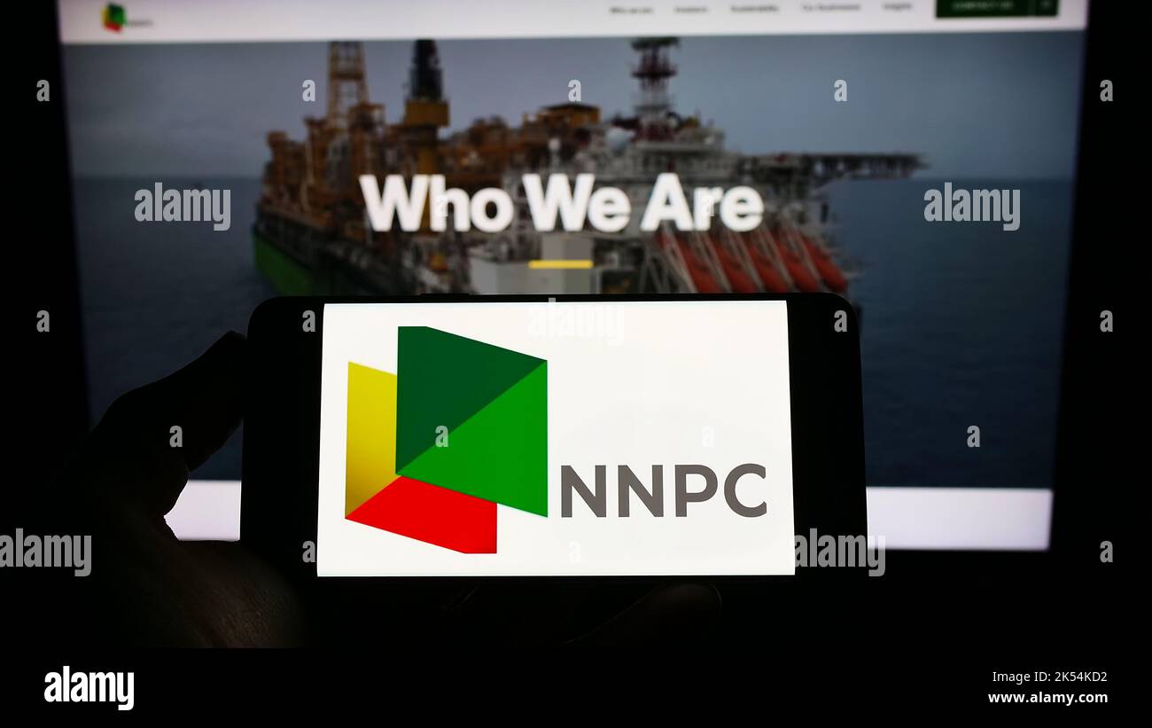 Person, die das Smartphone mit dem Logo der nigrischen National Petroleum Company Limited (NNPC) auf dem Bildschirm vor der Webseite hält. Konzentrieren Sie sich auf die Telefonanzeige. Stockfoto