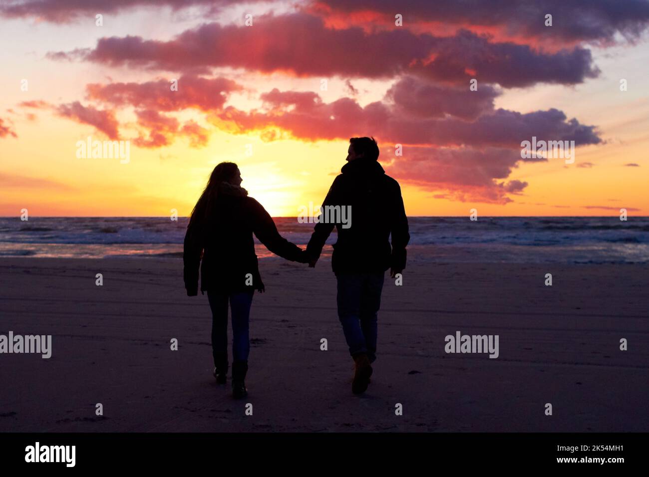 Die Natur hält die Magie am Leben. Silouehette eines Pärchens, das sich bei Sonnenuntergang am Strand küsst. Stockfoto