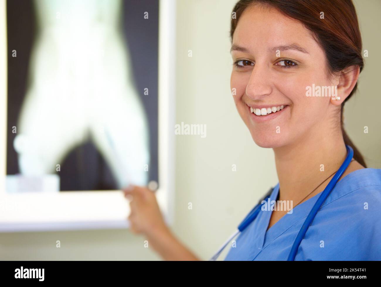 Das Krankenhaus ist mein zweites Zuhause. Porträt eines lächelnden Medizinstudenten, der auf ein Bild einer Röntgenaufnahme zeigt. Stockfoto