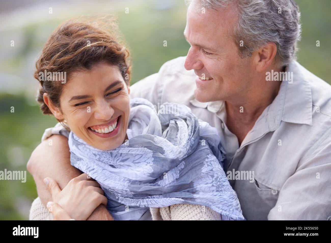 Sie finden immer Zeit zum Lachen. Ein reifes Paar lacht und umarmt, während sie einen Tag in der Natur genießen. Stockfoto