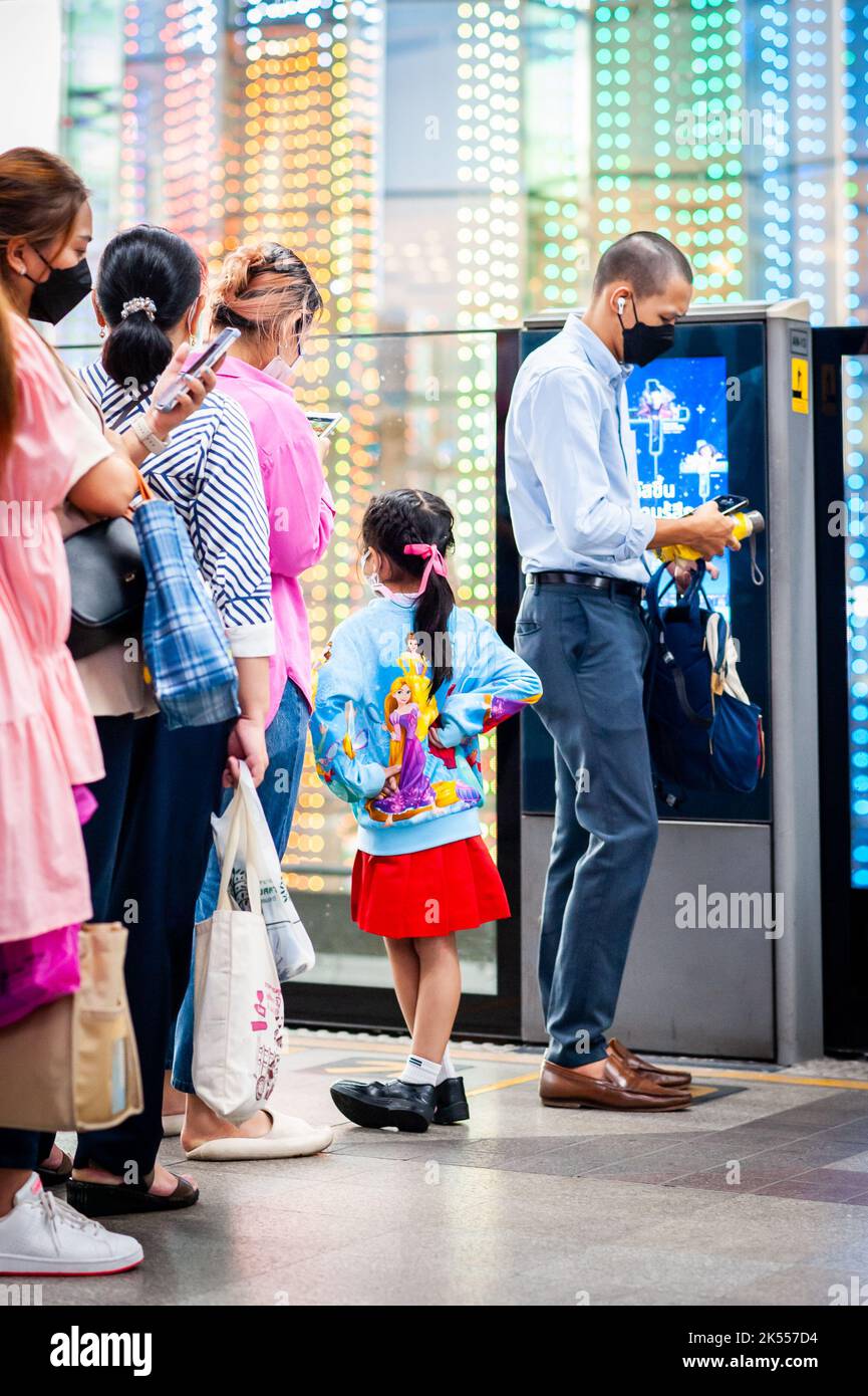 Ein süßes thailändisches Mädchen steht auf dem Bangkok BTS Sky Train Bahnsteig und trägt ihren Disney-Pullover. Stockfoto