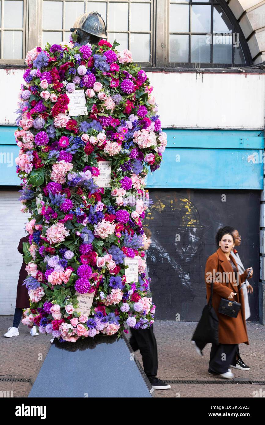 REDAKTIONELLE VERWENDUNG NUR die Sherlock Holmes Statue wird von Netflix mit einer Blumenverjüngungskur ausgestattet, um die Veröffentlichung ihrer neuesten Fortsetzung 'Enola Holmes 2' vor dem Bahnhof Baker Street in London zu feiern. Bilddatum: Donnerstag, 6. Oktober 2022. Stockfoto