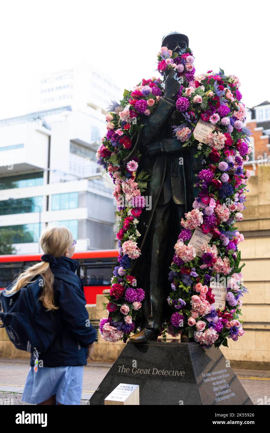 REDAKTIONELLE VERWENDUNG NUR die Sherlock Holmes Statue wird von Netflix mit einer Blumenverjüngungskur ausgestattet, um die Veröffentlichung ihrer neuesten Fortsetzung 'Enola Holmes 2' vor dem Bahnhof Baker Street in London zu feiern. Bilddatum: Donnerstag, 6. Oktober 2022. Stockfoto