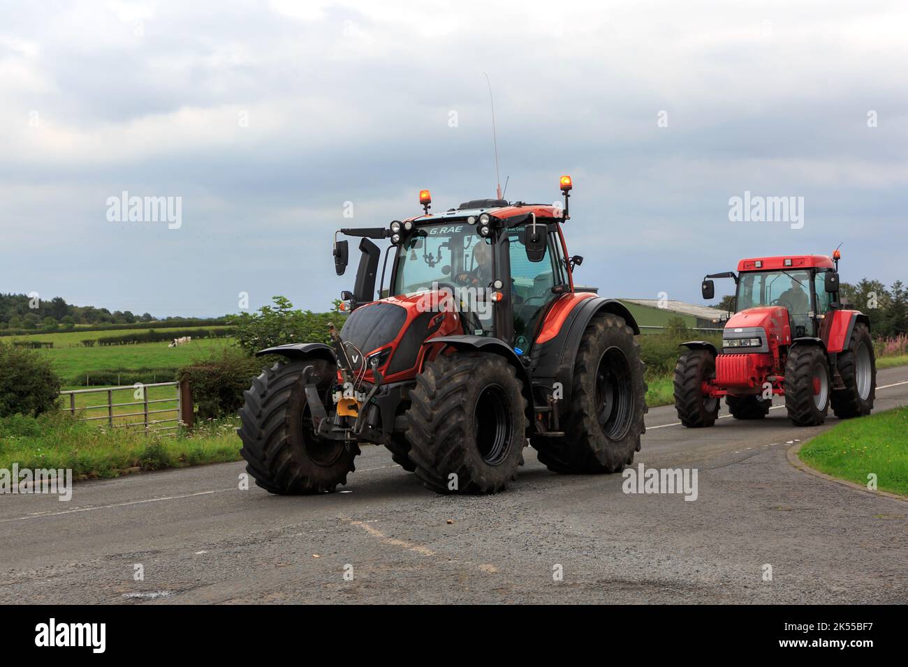 Eastriggs, Schottland - 04. September 2022: Valtra-Traktor gefolgt von einem McCormick MC 135-Traktor, der von einem örtlichen Wohltätigkeitslauf zurückkehrt Stockfoto
