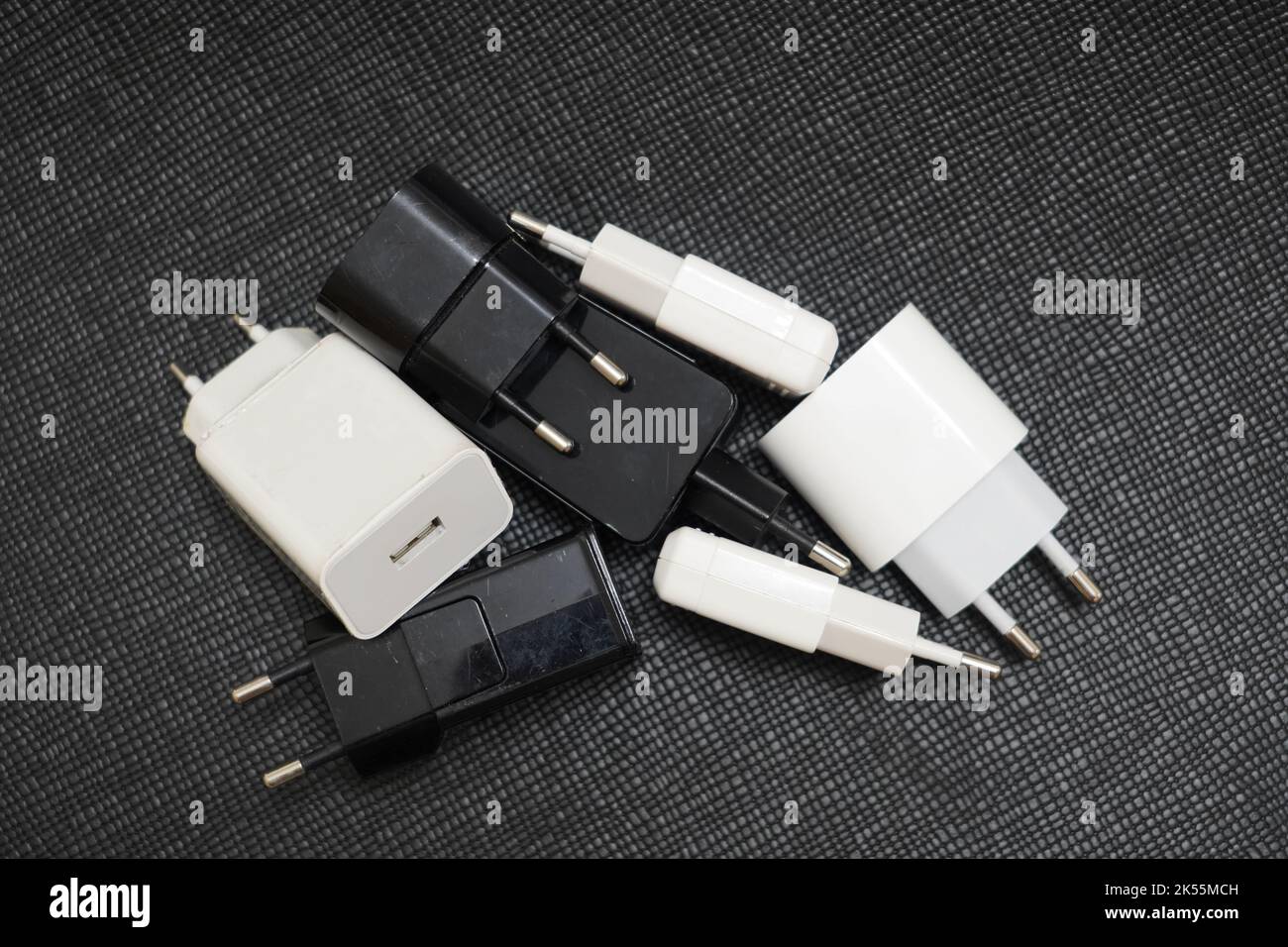 Viele Telefonladegerät-Adapter verschiedener Typen auf schwarzem Hintergrund Stockfoto