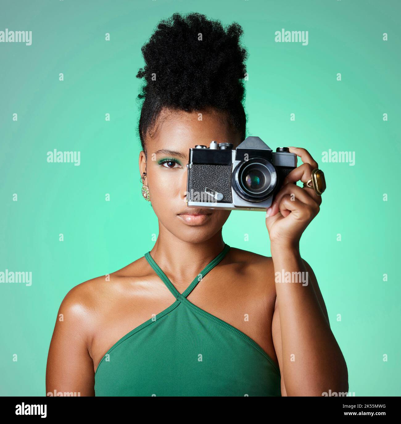 Schwarze Frau, Fotografin oder Modelin auf grünem Studiohintergrund in kreativer Kunst, Bekleidungsmarke oder Designer Social Media Blog. Hochformat, Kamera Stockfoto