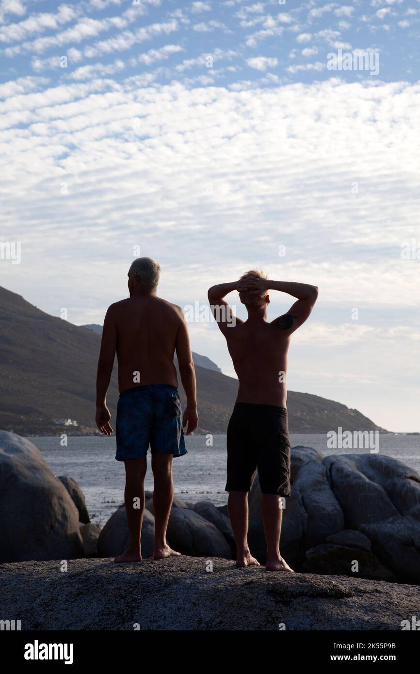 Zwei Männer auf Rocks am Bakoven Beach in Sundow in Kapstadt, Südafrika Stockfoto