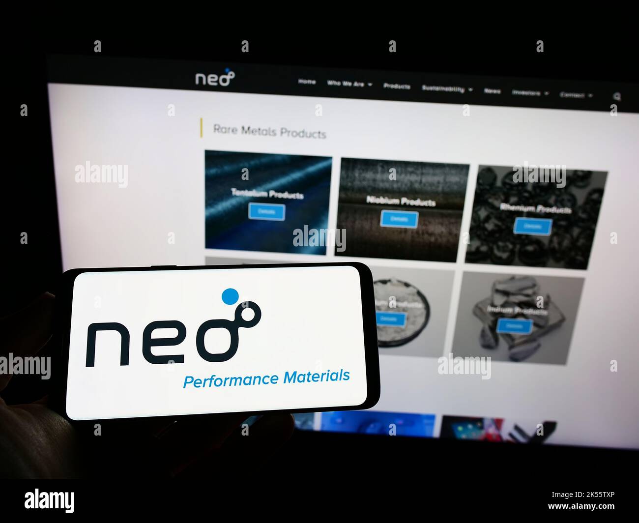 Person, die Mobiltelefon mit dem Logo des kanadischen Unternehmens Neo Performance Materials auf dem Bildschirm vor der Business-Webseite hält. Konzentrieren Sie sich auf die Telefonanzeige. Stockfoto