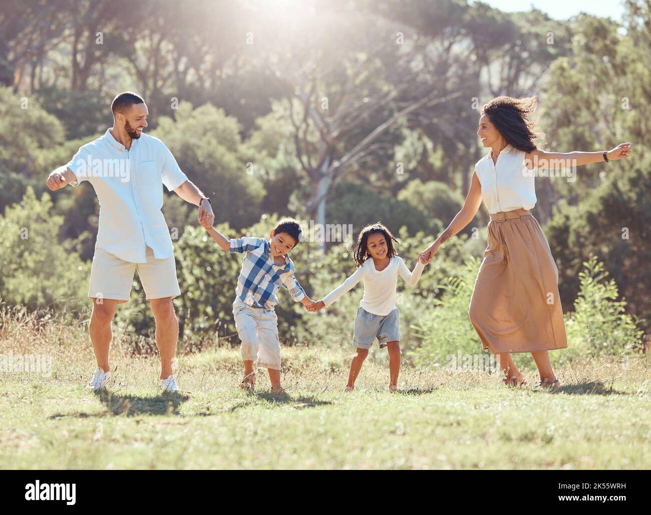 Freiheit, glückliche Familie und Spaß in einem Park mit schwarzen Kindern und Eltern, die sich auf dem Rasen verbinden und spielen. Liebe, Energie und Kinder aufgeregt und glücklich, während Stockfoto