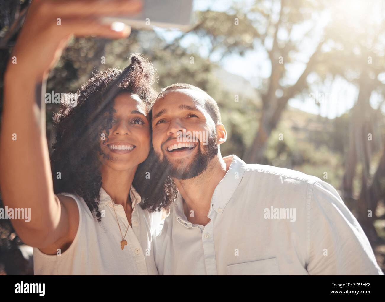 Schwarzes Paar, Lächeln und Telefon Selfie in der Natur für Sommerurlaub, Abenteuer und Spaß zusammen im Freien. Porträt eines glücklichen afrikanischen Mannes und einer glücklichen Frau in Stockfoto