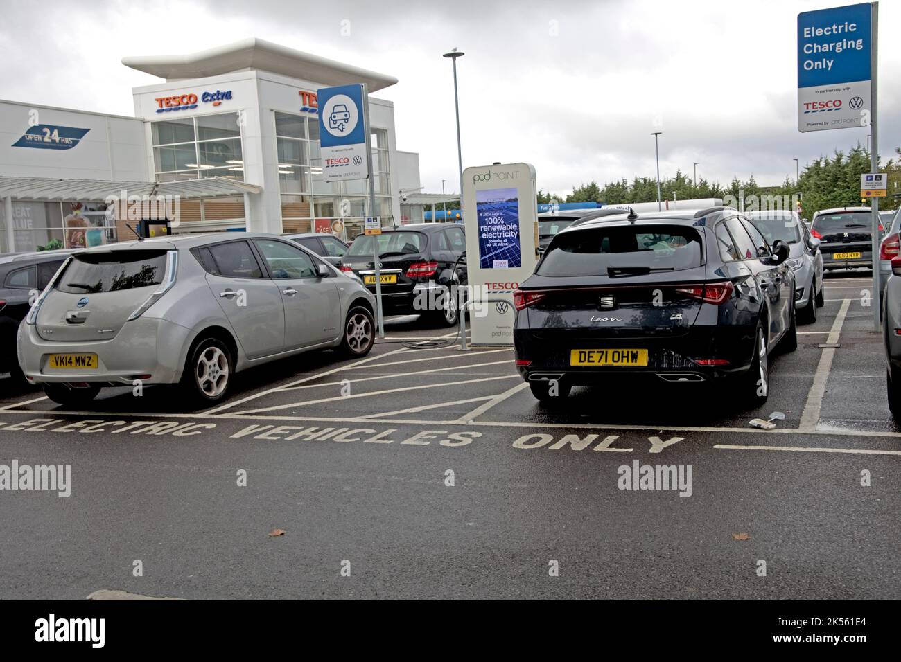 Zwei Elektrofahrzeuge laden an Tesco-freien Ladestationen mit 100 % erneuerbarem Strom bei Quedgely Gloucester UK Stockfoto