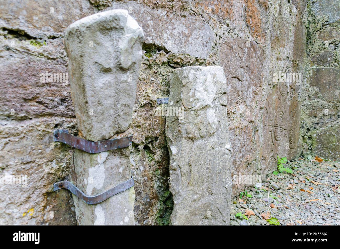 Alte geschnitzte Grabsteine, die in den Ruinen der Inchagoil-Kirche, Lough Corrib, Republik Irland, an der Wand befestigt sind Stockfoto