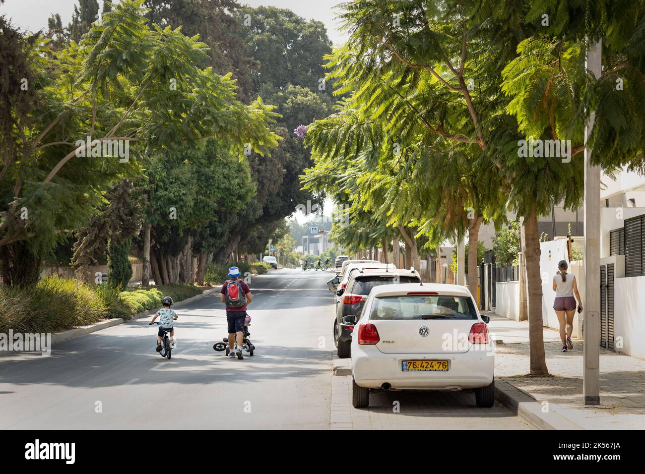 Auf der Straße in Yom Kippur Holiday, Israel, laufen und fahren Menschen mit Fahrrädern. Stockfoto