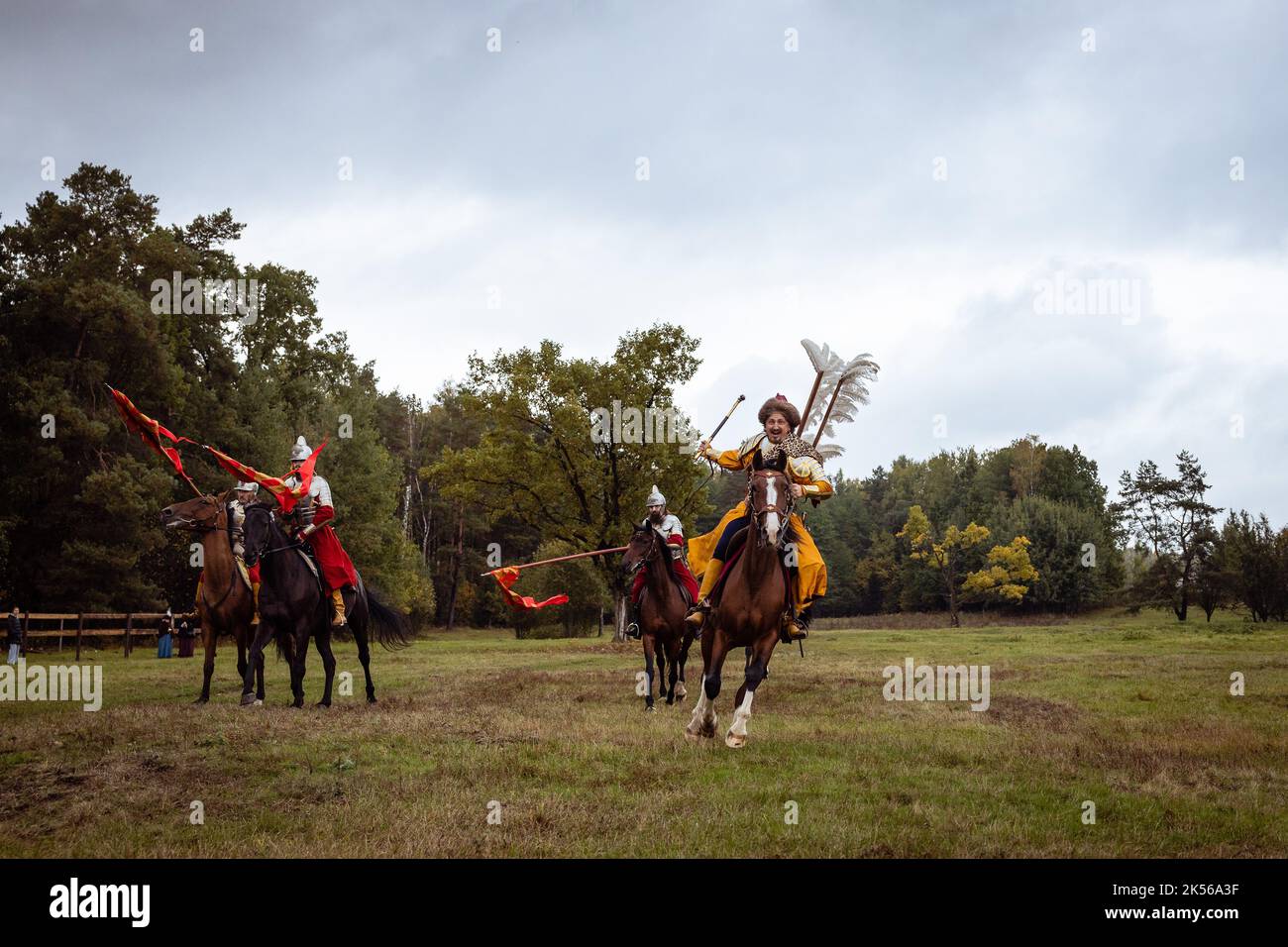 Living History: Eine Pferdeschau im Stil des 17.. Jahrhunderts. Eine Gruppe von Reitern galoppiert direkt auf die Kamera, angeführt von einem Mann in einem Anzug mit Flügel Stockfoto
