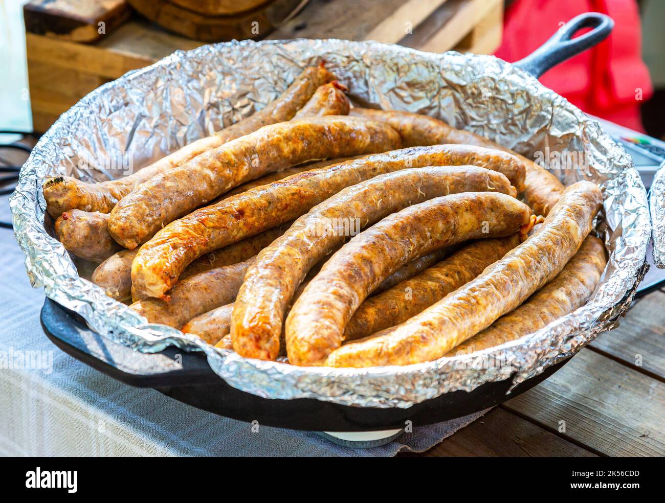 Saftig appetitlich gegrillte Würstchen in einer Pfanne in Folie aus nächster Nähe Stockfoto
