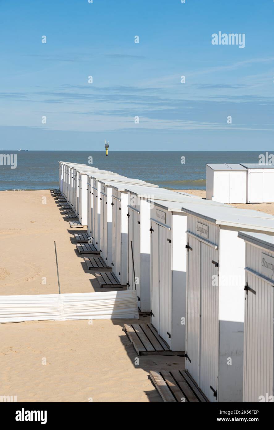 Knokke Heist, Flämische Region - Belgien - 04 03 2021 Weiße Strandhütten in einer Reihe am Sandstrand in der Nebensaison Stockfoto