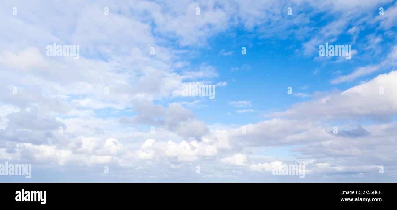 Blauer Himmel mit weißen Altocumuluswolken am Tag, natürliche Panorama-Hintergrund-Fototextur Stockfoto