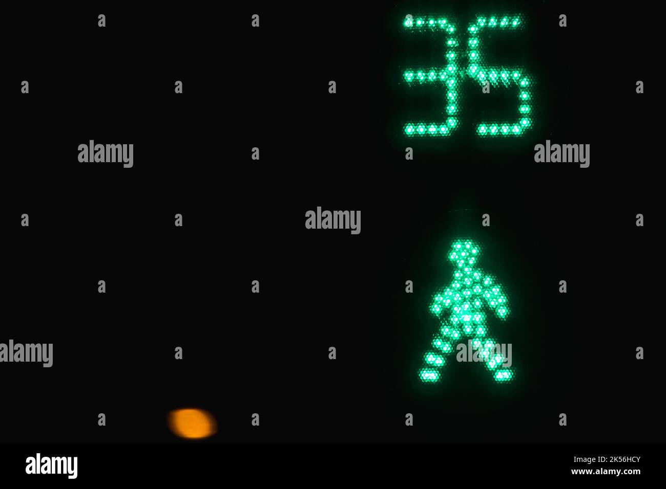 Fußgängerübergangsampel zeigt grün an. Signal mit Sekundenanzeige über schwarzen Nachthintergrund senden lassen Stockfoto