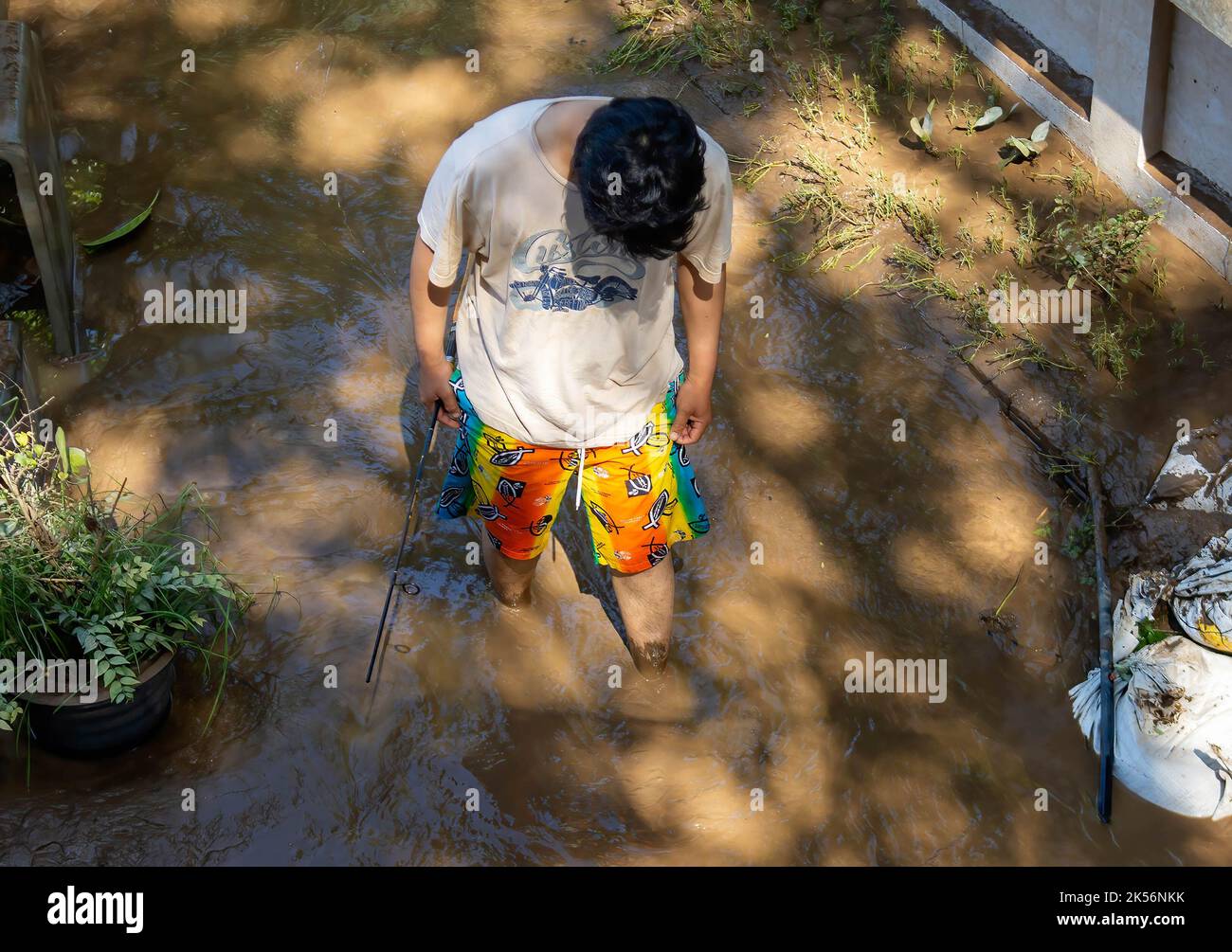 Chiang Mai, Thailand. 5. Oktober 2022. Ein Mann sah in der Folge im Schlamm laufen. Die Hochwassersituation in Chiang Mai im Norden Thailands wird durch sinkende Wasserstände erleichtert. Die Überschwemmungen haben die Handelsgebiete, die Chang Khlan Road und den Nachtbasar beschädigt. (Bild: © Pongmanat Tasiri/SOPA-Bilder über ZUMA Press Wire) Stockfoto