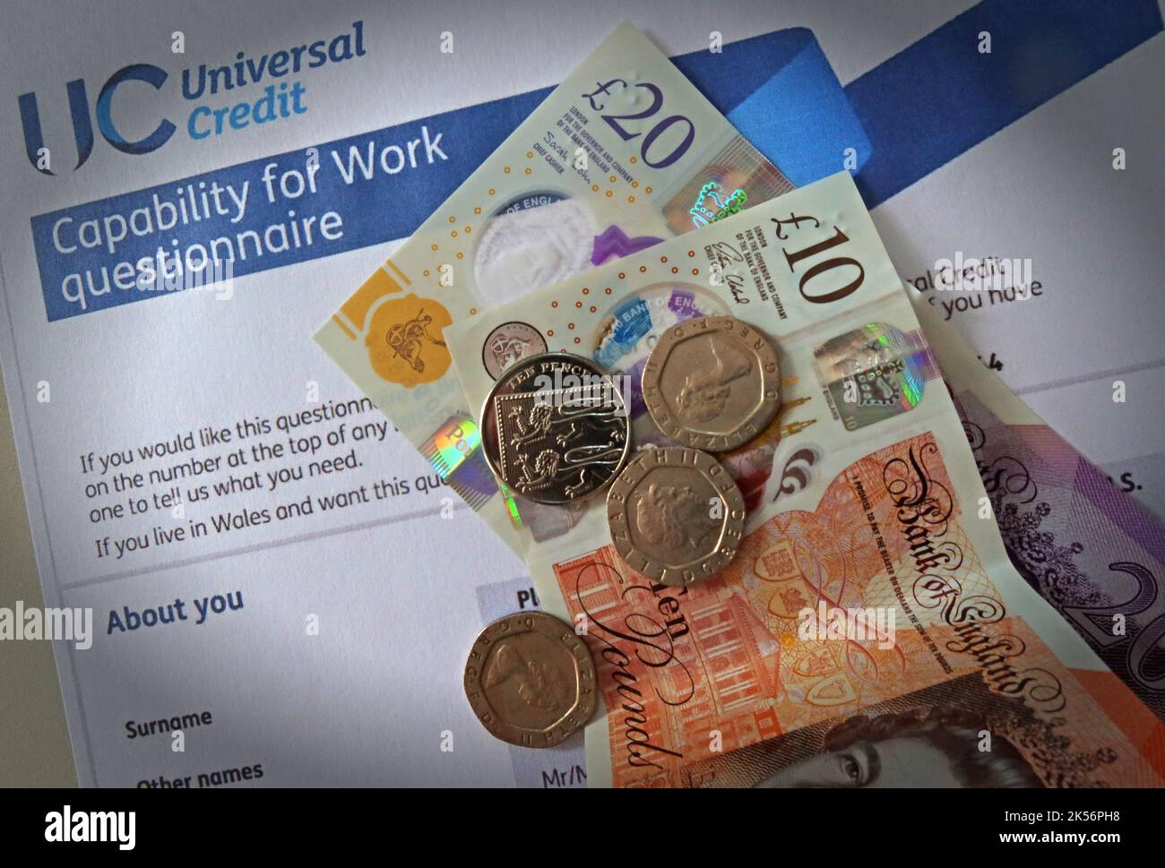 UC Universal Credit – Fragebogen zur Arbeitsfähigkeit, mit Bargeld, Pfundnoten Stockfoto