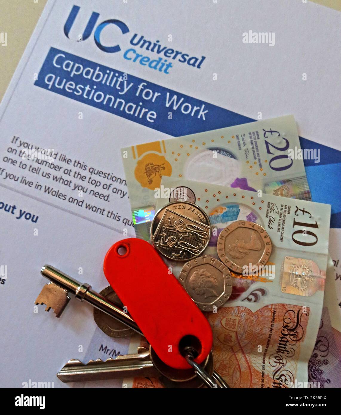 UC Universal Credit – Fragebogen zur Arbeitsfähigkeit mit Bargeld, Pfundnoten und Hausschlüsseln Stockfoto