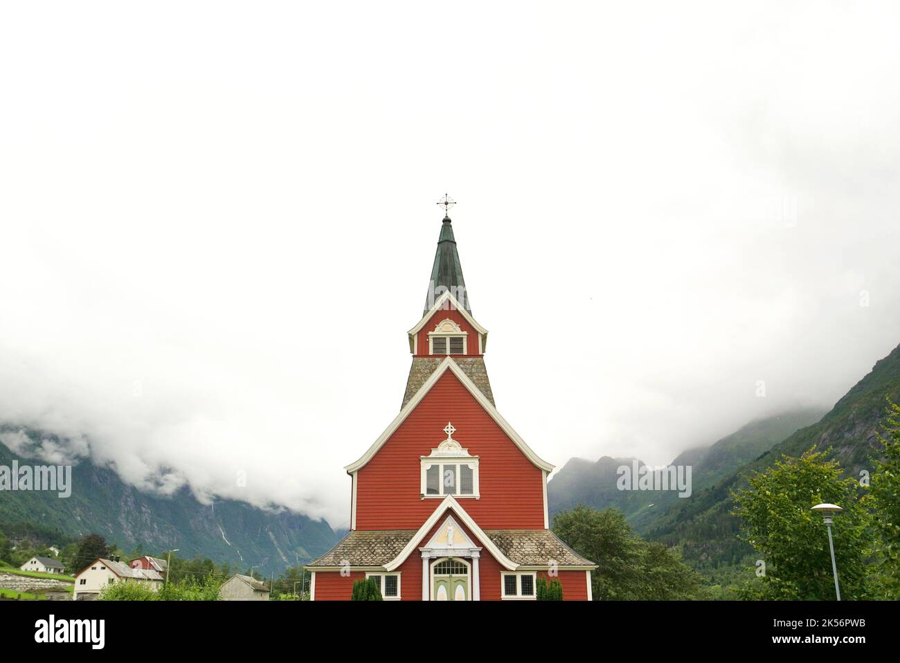 Alte 'Neue Kirche', erbaut 1934, Olden, Norwegen. Norwegen rote Kirche. Holzkirche. Umgeben von Bergen und niedrigen Wolken. Stockfoto