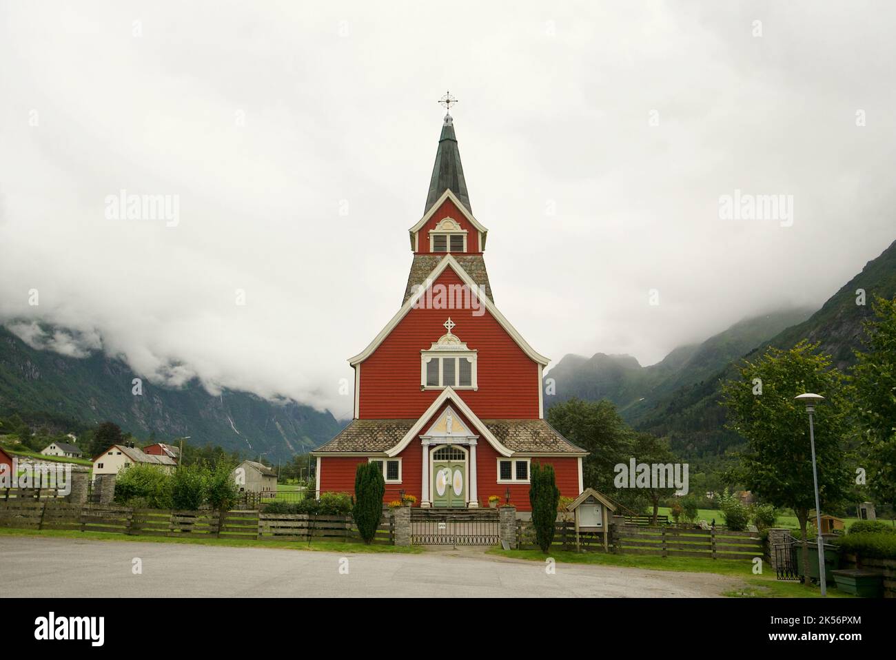 Alte 'Neue Kirche', erbaut 1934, Olden, Norwegen. Norwegen rote Kirche. Holzkirche. Umgeben von Bergen und niedrigen Wolken. Stockfoto