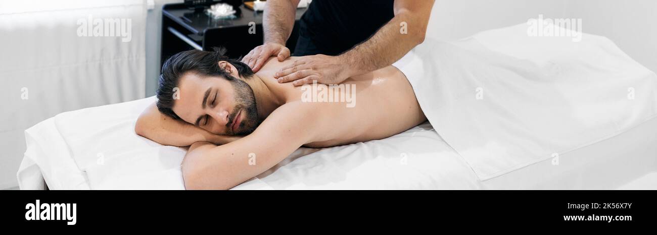 Massage für Männer. Gutaussehender Mann verbringt Zeit im Spa und bekommt eine Ölmassage und Aromatherapie Stockfoto