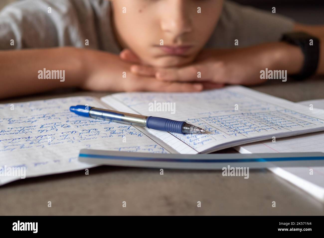 Trauriger müder Junge, der sitzt und Bücher und Notizbücher anschaut. Bildung, Schule, Lernschwierigkeiten, Legasthenie-Konzept Stockfoto