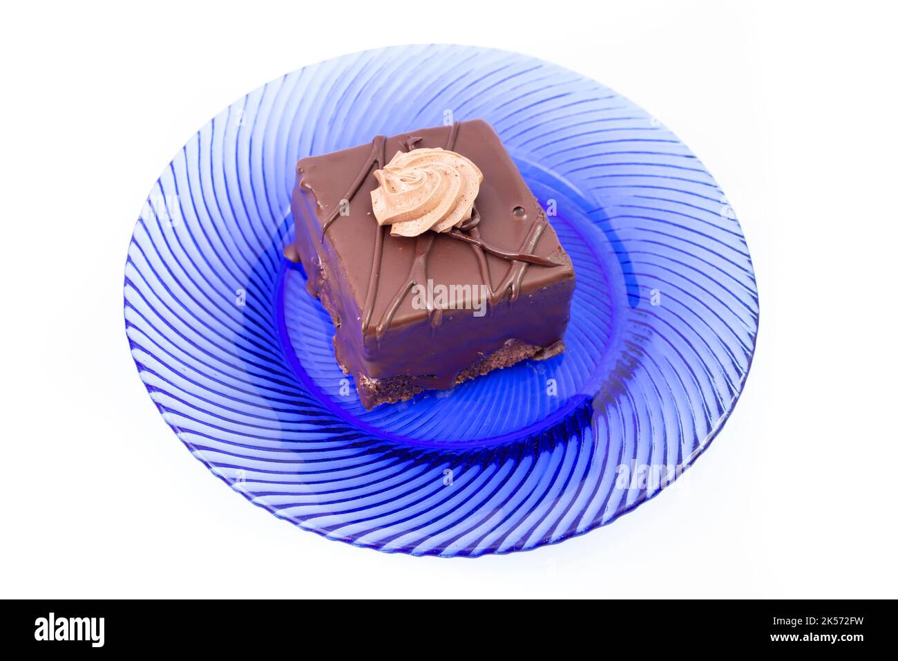 Amandine Kuchen, quadratische Portion, auf einer blauen Glasplatte, isoliert auf weißem Hintergrund Stockfoto