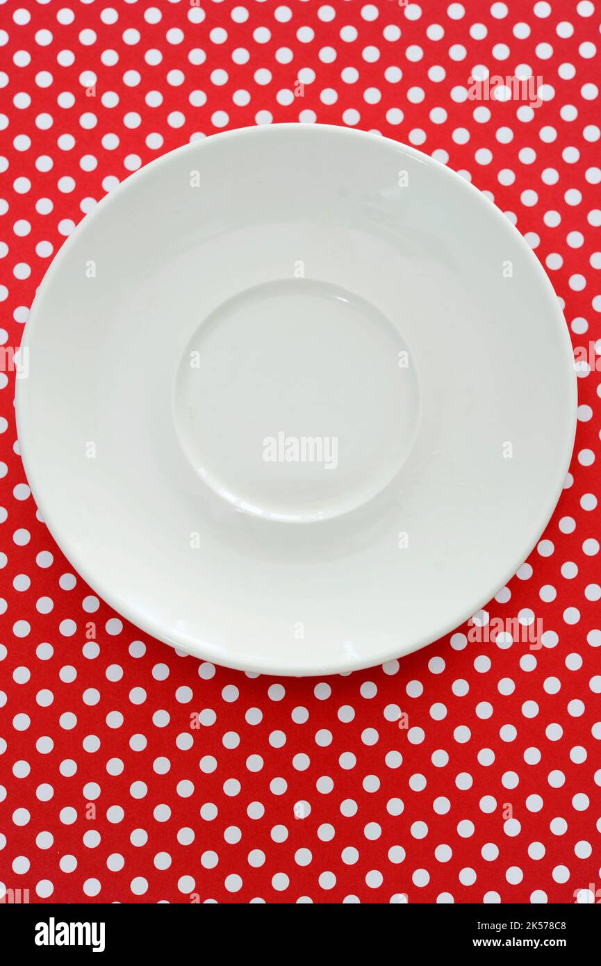 Rote und weiße Tupfen mit weißer Platte wie ein grafischer Hintergrund mit Kopierfläche Stockfoto