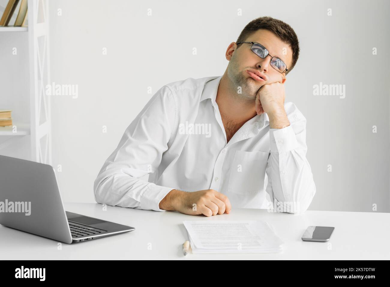 Gelangweilter Mann ahnungslose Arbeit alberne Aufgaben desinteressiert Stockfoto