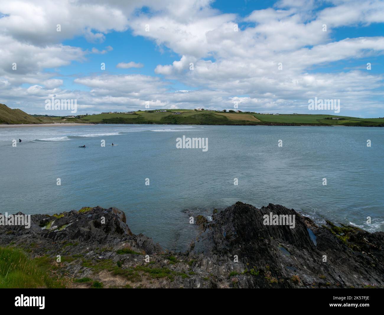 West Cork, Irland, 12. Juni 2022. Irische Landschaft. Clonakilty Bay im Sommer. Weiße Cumulus Wolken in einem blauen Himmel. Menschen auf See. Stockfoto