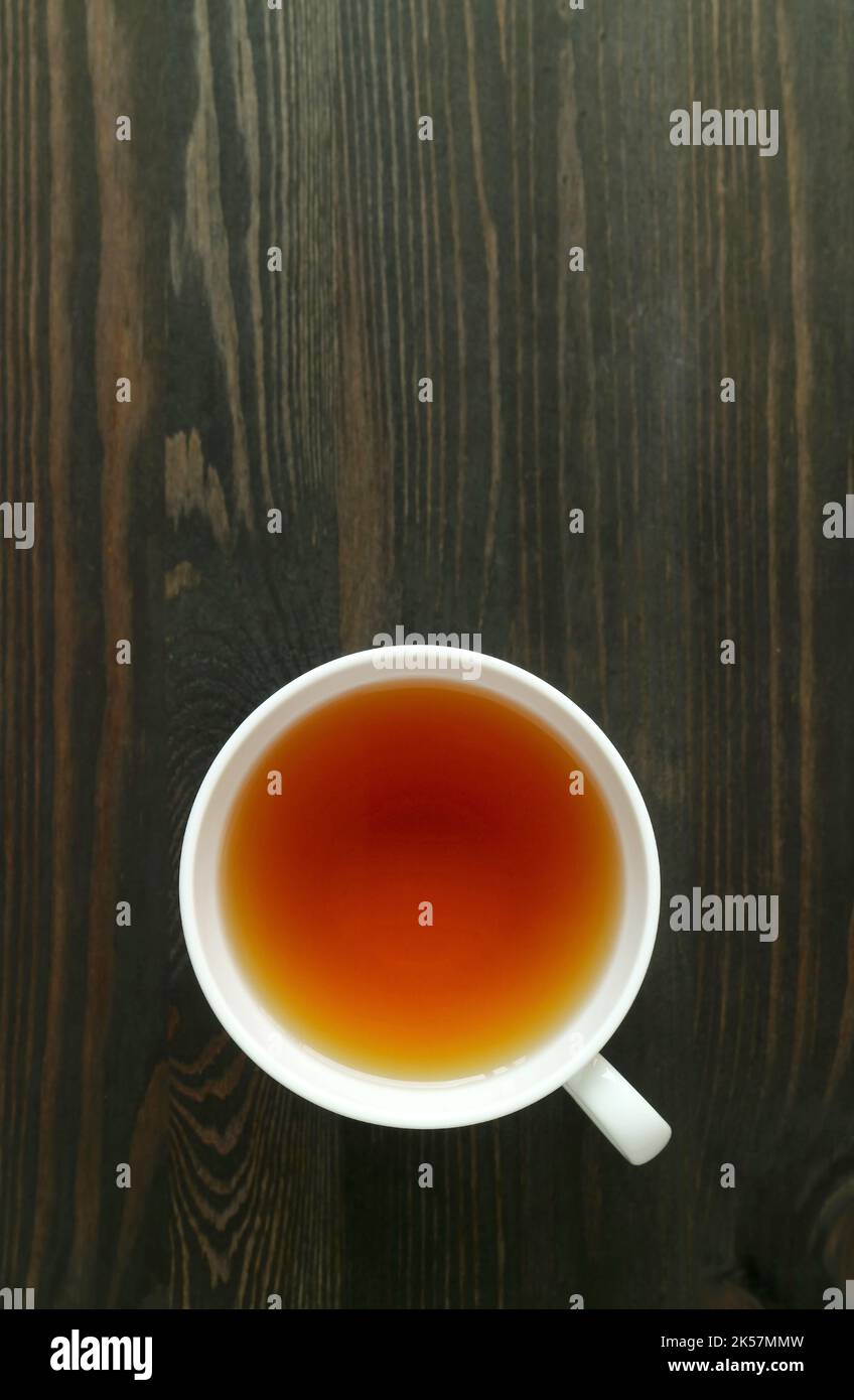 Eine Tasse japanischer gerösteter Gerstentee oder Mugicha isoliert auf einem dunkelbraunen Holztisch Stockfoto