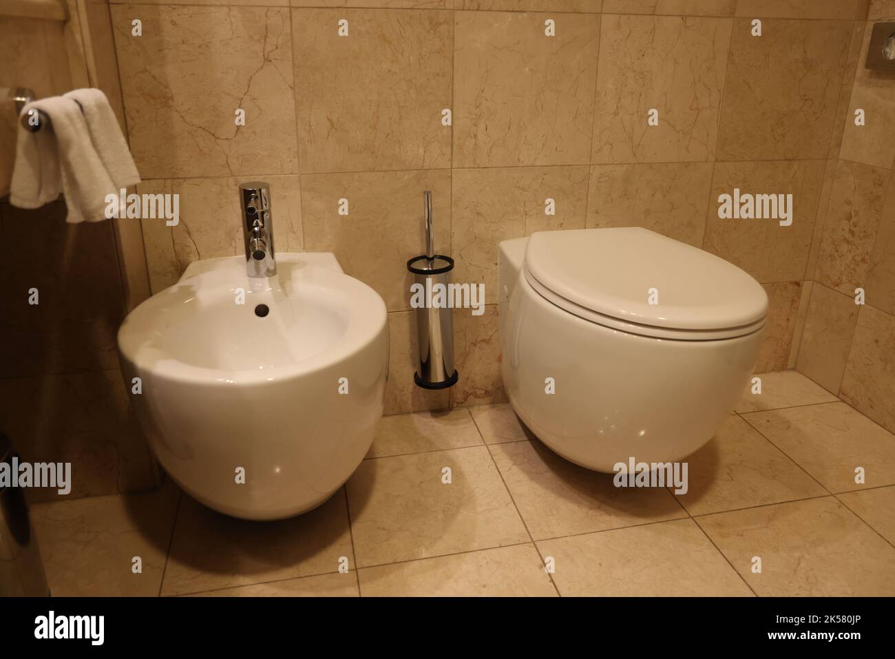 Weiße Toilette und Bidet nebeneinander im Badezimmer Stockfoto