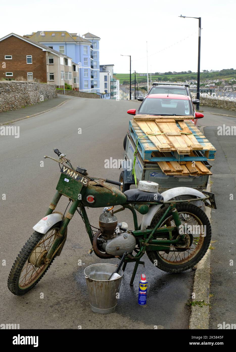 Ein sehr altes Motorrad, das in Port Erin, Isle of man, auf Reparatur wartet. Stockfoto