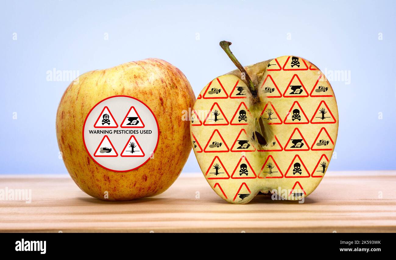 Warnungen auf geschnittenen Apfel, Warnung vor Umweltschäden durch Pestizid- und Herbizideinsatz in der industriellen landwirtschaftlichen Lebensmittelproduktion, Schäden an Umwelt Stockfoto