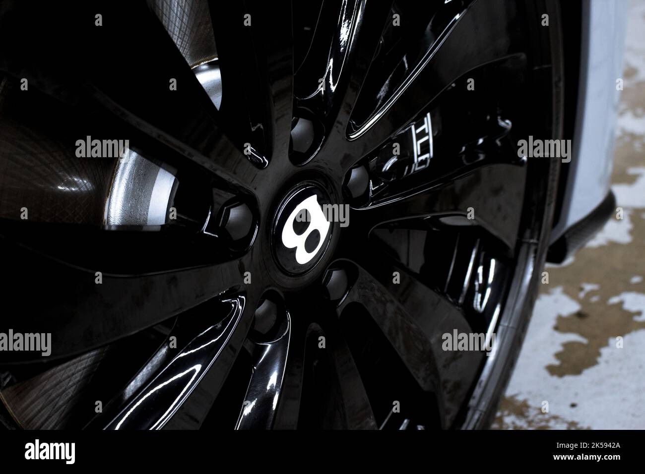 Das Vorderrad-Emblem auf dem Vorderrad in glänzendem Schwarz, Alloy Wheel eines Bentley Flying Spur aus dem Jahr 2022 Stockfoto