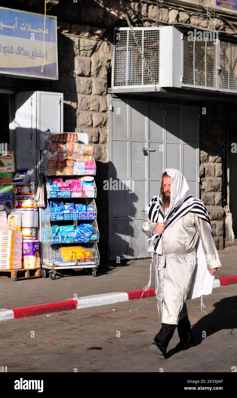 Ein orthodoxer jüdischer Mann, der durch das arabische Viertel in Ost-Jerusalem auf dem Weg zur Klagemauer in Jerusalem spaziert. Stockfoto
