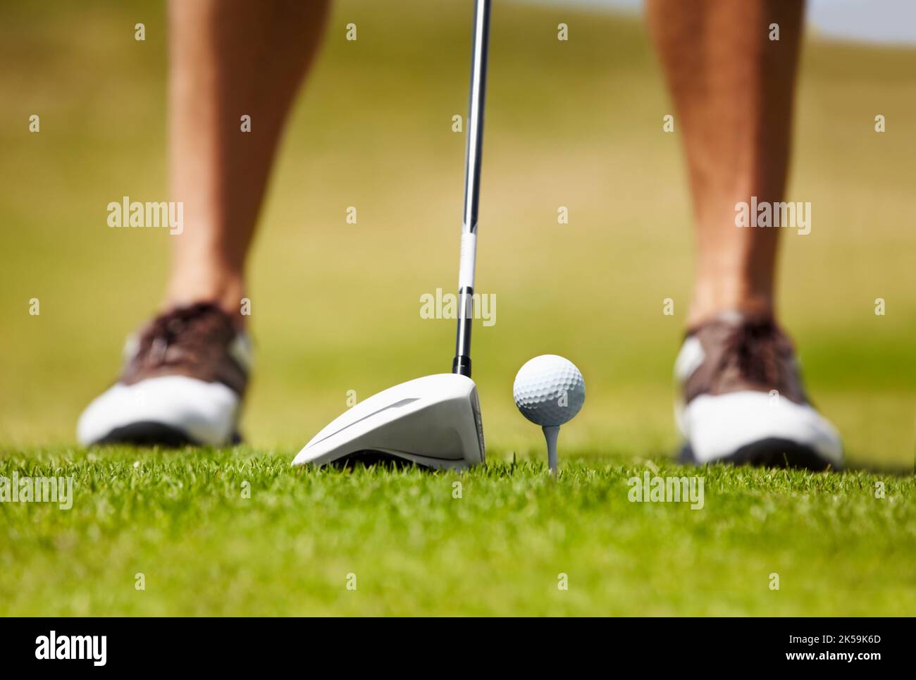Fahren Sie auf das Grün. Zugeschnittenes Bild eines Golfspielers, der kurz vor dem Golfball auf dem Fairway steht. Stockfoto