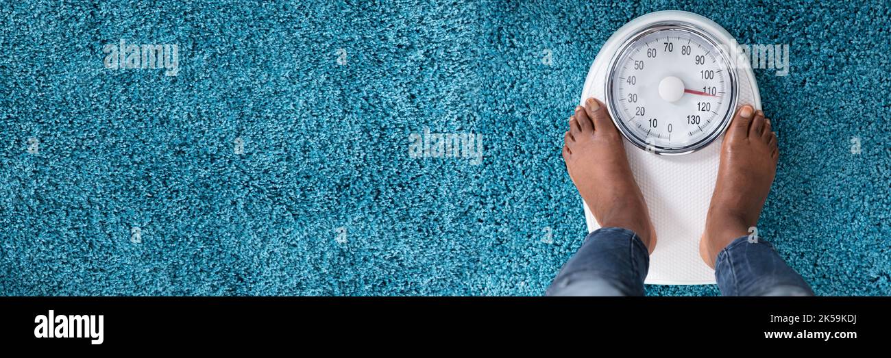 Schwarze Frau Füße Auf Skala. Gewichtsverlust Und Adipositas Stockfoto
