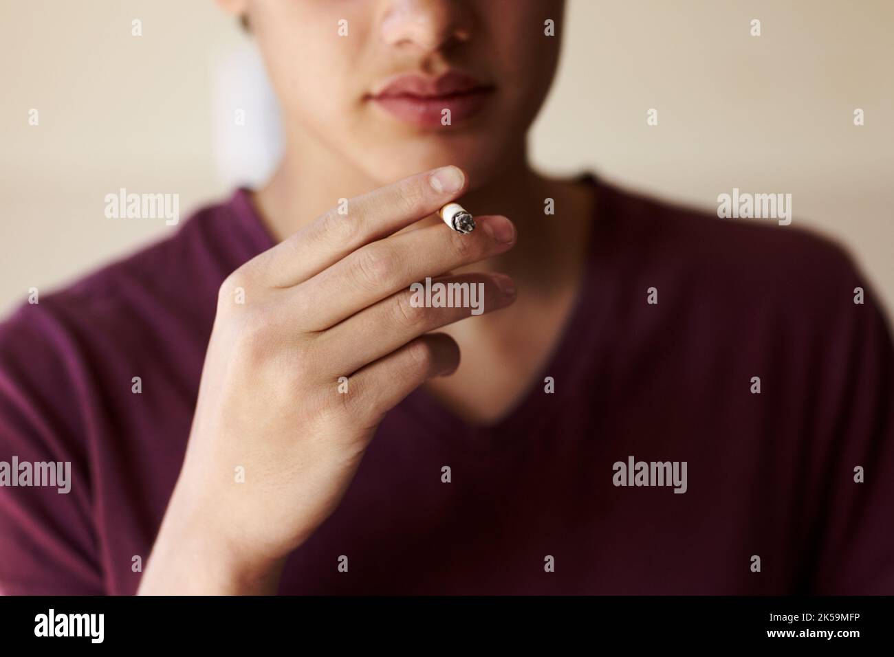 Der Beginn einer ungesunden Gewohnheit. Kurze Nahaufnahme einer Person, die raucht. Stockfoto