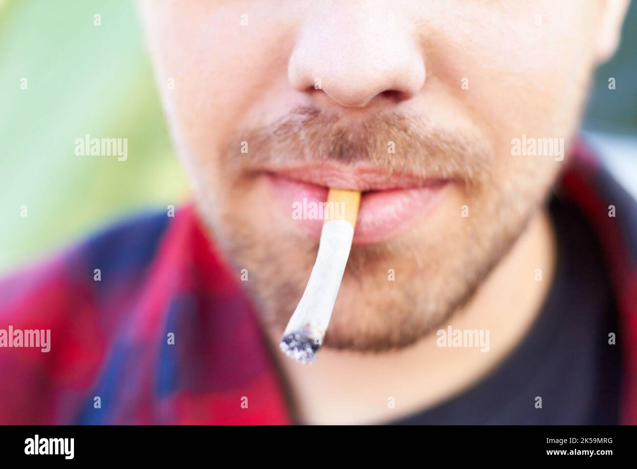Alles hat ein Tor. Ein Mann, der Marihuana in einer Zigarette raucht. Stockfoto