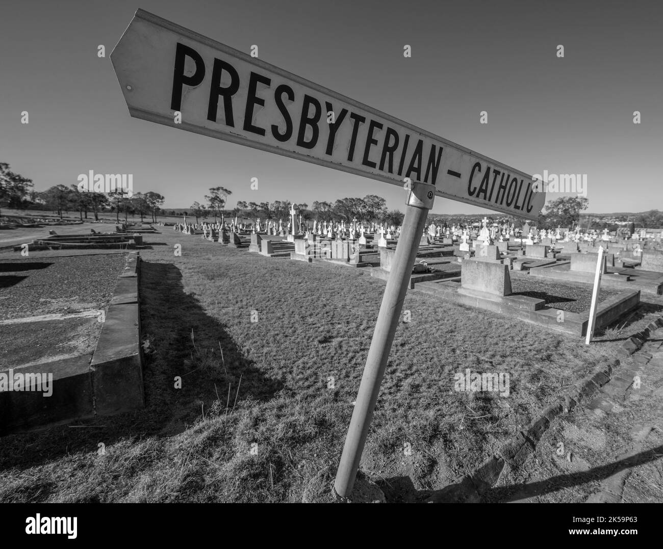 Schwarzweißfoto des Schilds auf dem Friedhof von Tenterfield mit der Trennlinie zwischen dem katholischen und dem presbyterischen Teil des Friedhofs Stockfoto