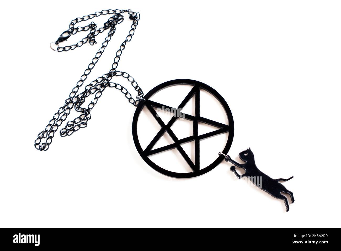 Kleine schwarze Katzenform, verbunden mit einer großen schwarzen Pentagramm-Kette, isoliert auf Weiß. Kreatives halloween Accessoire Konzept. Stockfoto