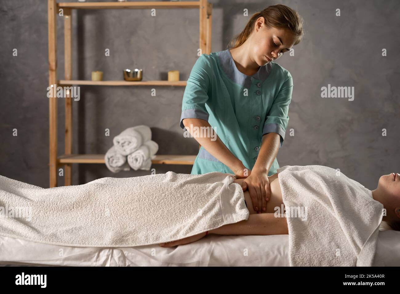 Weibliche Masseur massiert weiblichen Bauch in medizinischen Spa-Zentrum. Lymphdrainage, manuelle Massage Stockfoto